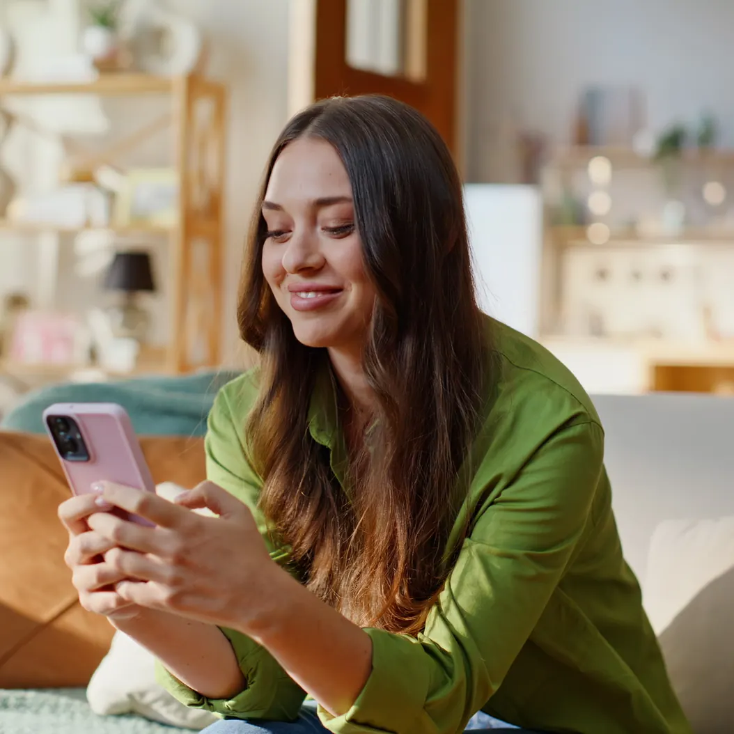 Hotel guest smiling as she messages on her phone